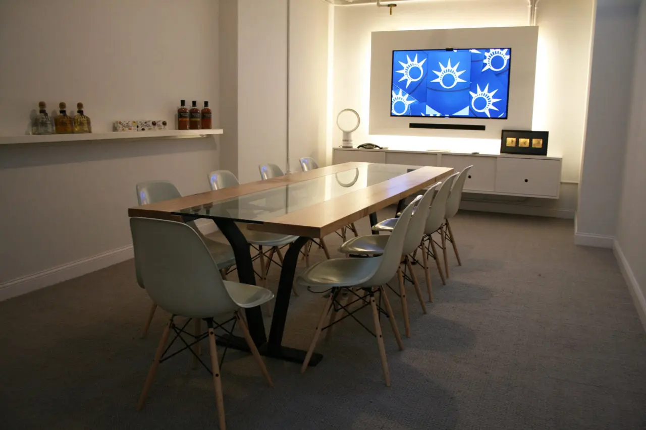 Commercial space furniture for the conference room - Colorado table with custom glass inset and luxury chairs in an office setting