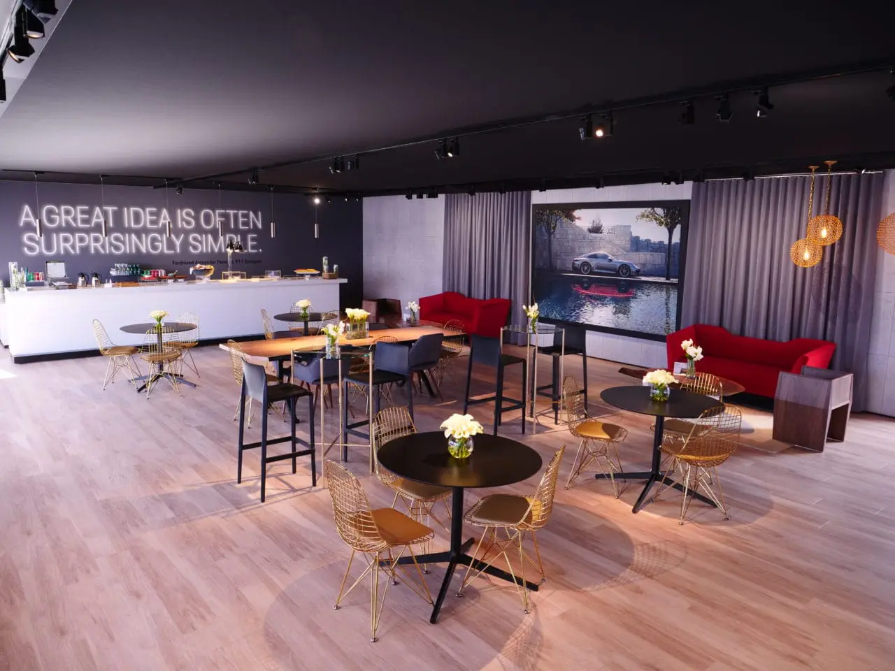 Commercial space furniture by SENTIENT for Porsche - walnut live edge table and furniture in porsche car show exhibition cafe