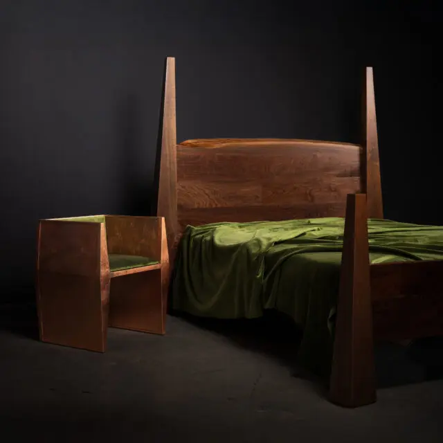 The SENTIENT Citadelle Bed crafted in walnut wood, paired with a Copper Sapience Chair featuring green velvet upholstery. The combination showcases a blend of modern craftsmanship and luxurious materials for a refined bedroom setup.