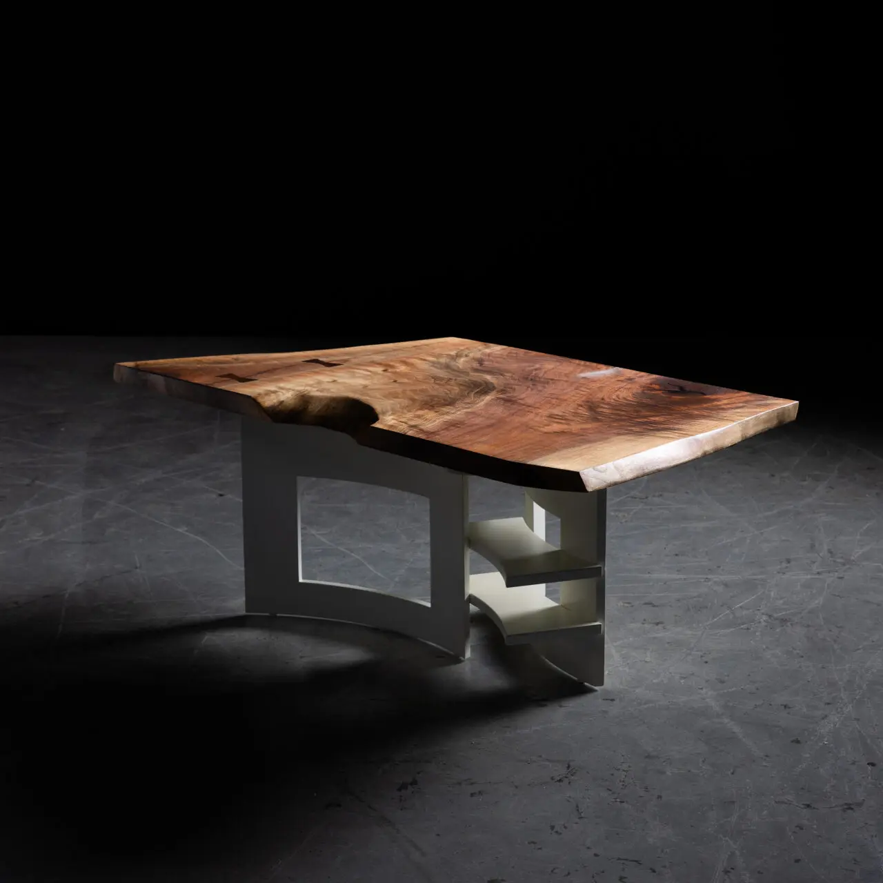A handcrafted live edge walnut coffee table featuring a rich wood grain top paired with a modern sculptural white base. The design combines organic and geometric elements, showcasing SENTIENT’s expertise in custom furniture creation.