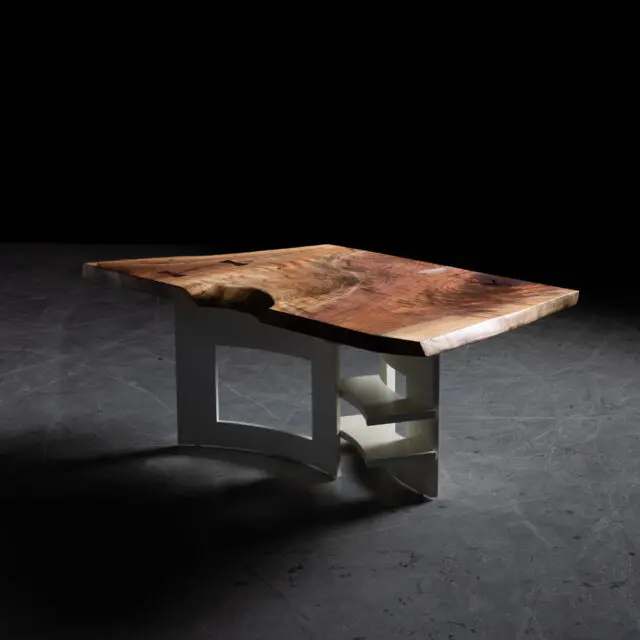 A handcrafted live edge walnut coffee table featuring a rich wood grain top paired with a modern sculptural white base. The design combines organic and geometric elements, showcasing SENTIENT’s expertise in custom furniture creation.