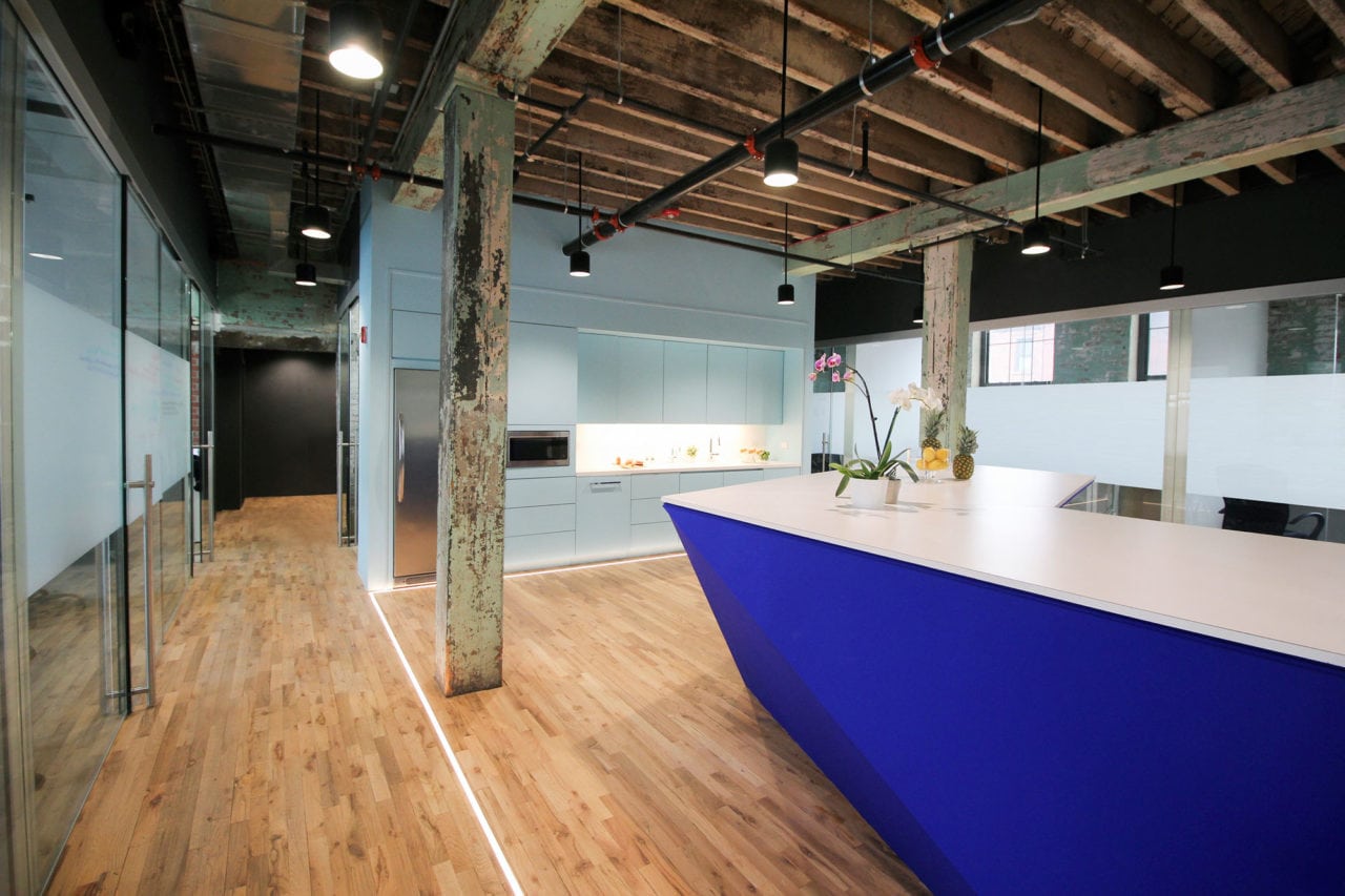 in a bond collective office SENTIENT contemporary designed custom furniture with a long low counter with blue accented wall 