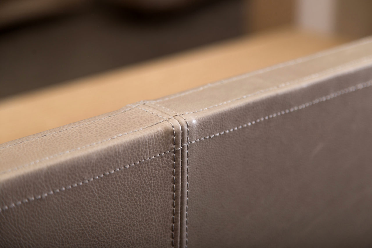 a detail of a stitched leather seam on a SENTIENT contemporary designed custom piece of upholstery furniture 