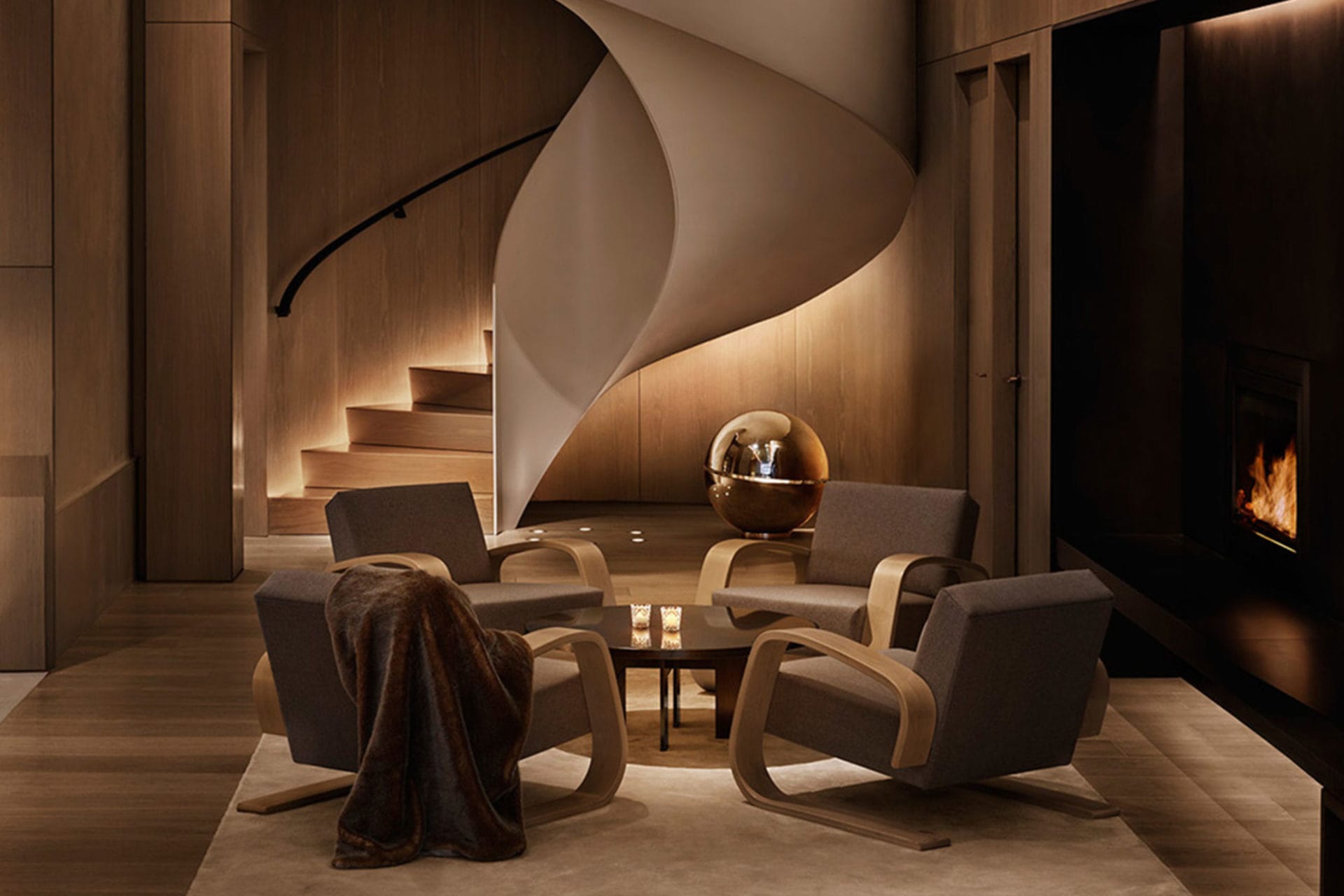 a custom SENTIENT contemporary coffee table with four chairs in a new york edition hotel setting with spiral staircase