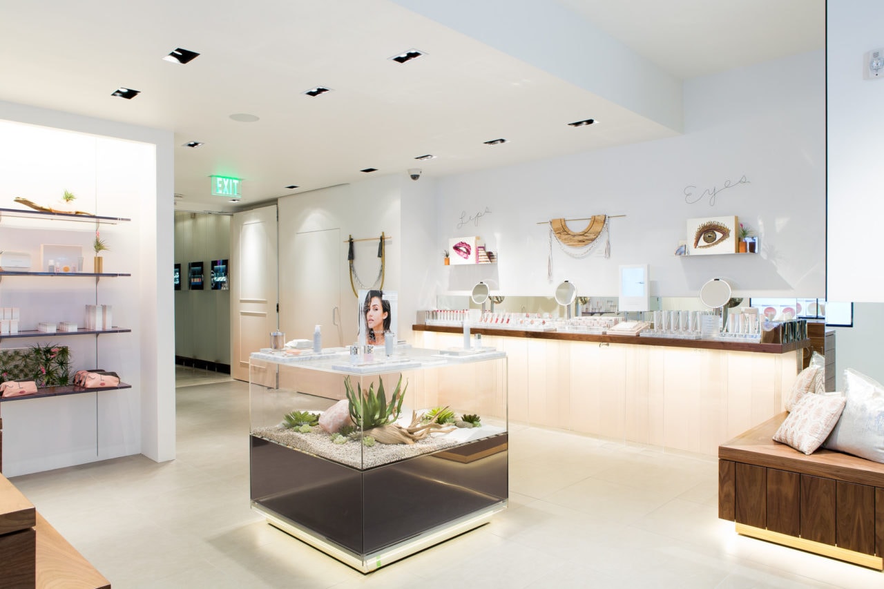 in an honest beauty retail space SENTIENT contemporary designed custom walnut counter tops and vitrine bases with beauty aids 
