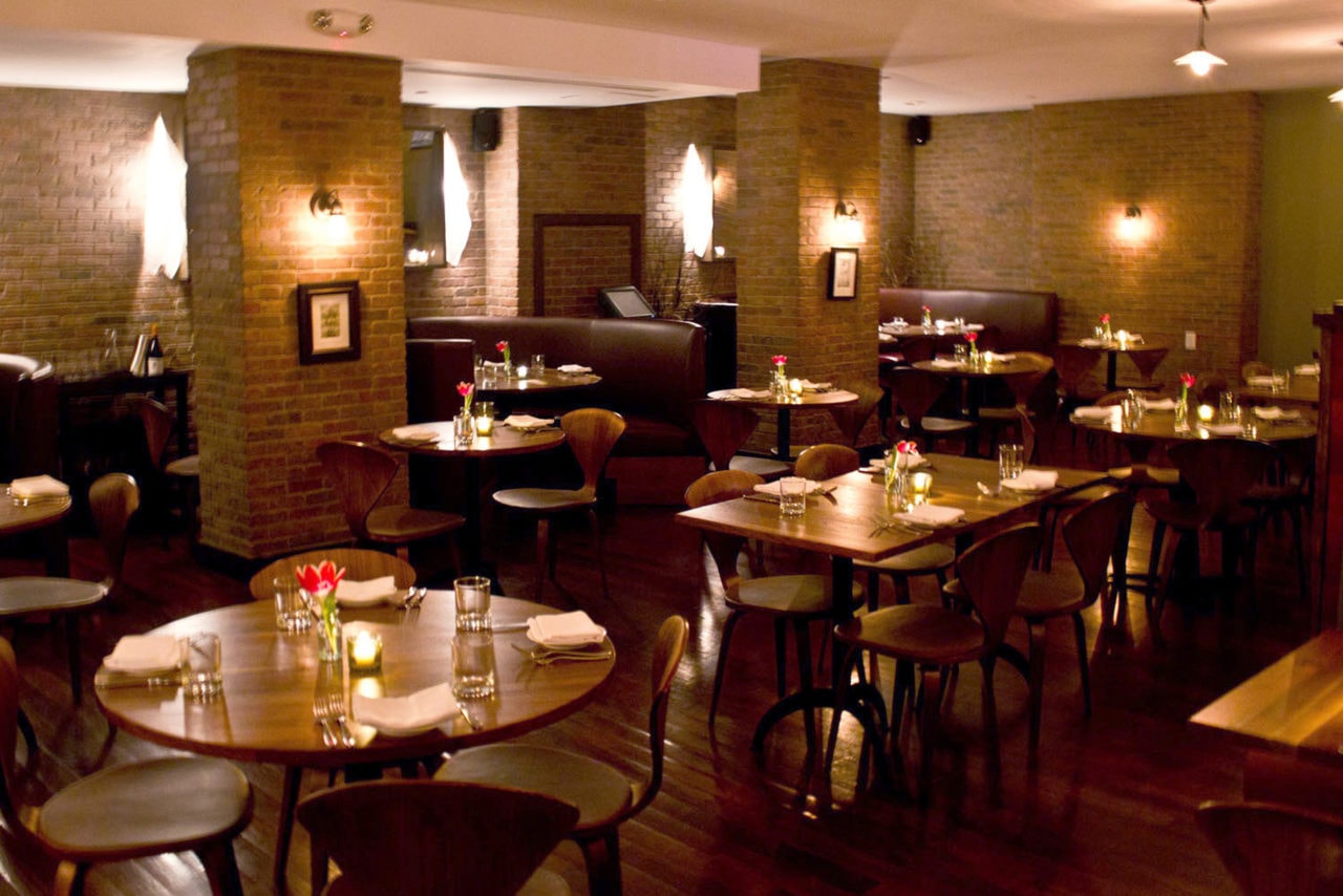 SENTIENT custom walnut wood tables and contemporary designed chairs in luxury bread and tulips restaurant with brick walls