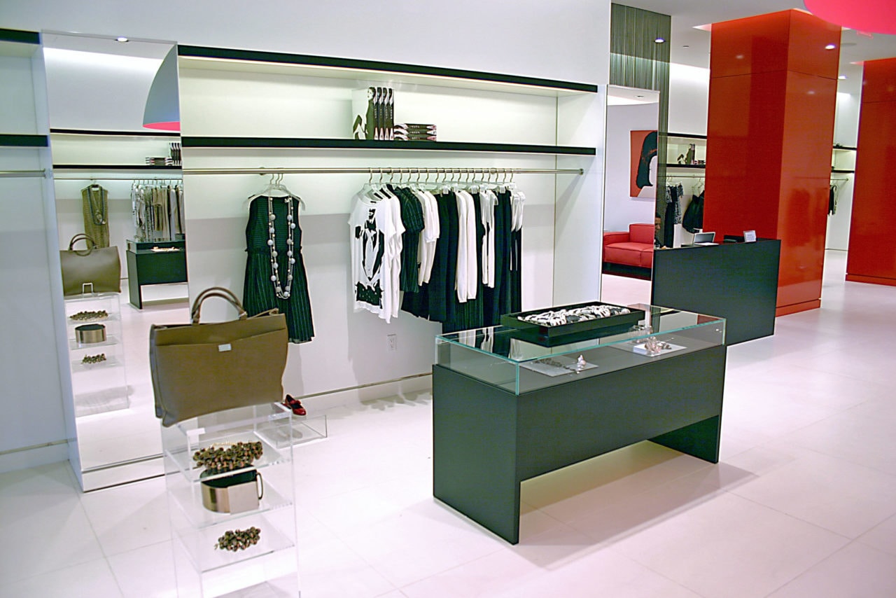 custom SENTIENT contemporary designed furniture in a Kritzia retail space with wood vitrine cabinet and pink and red accents