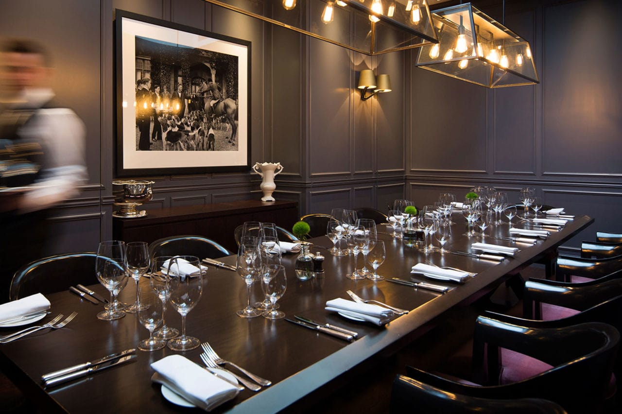 in a London edition hotel restaurant a SENTIENT contemporary design custom live edge table with luxury upholstered chairs