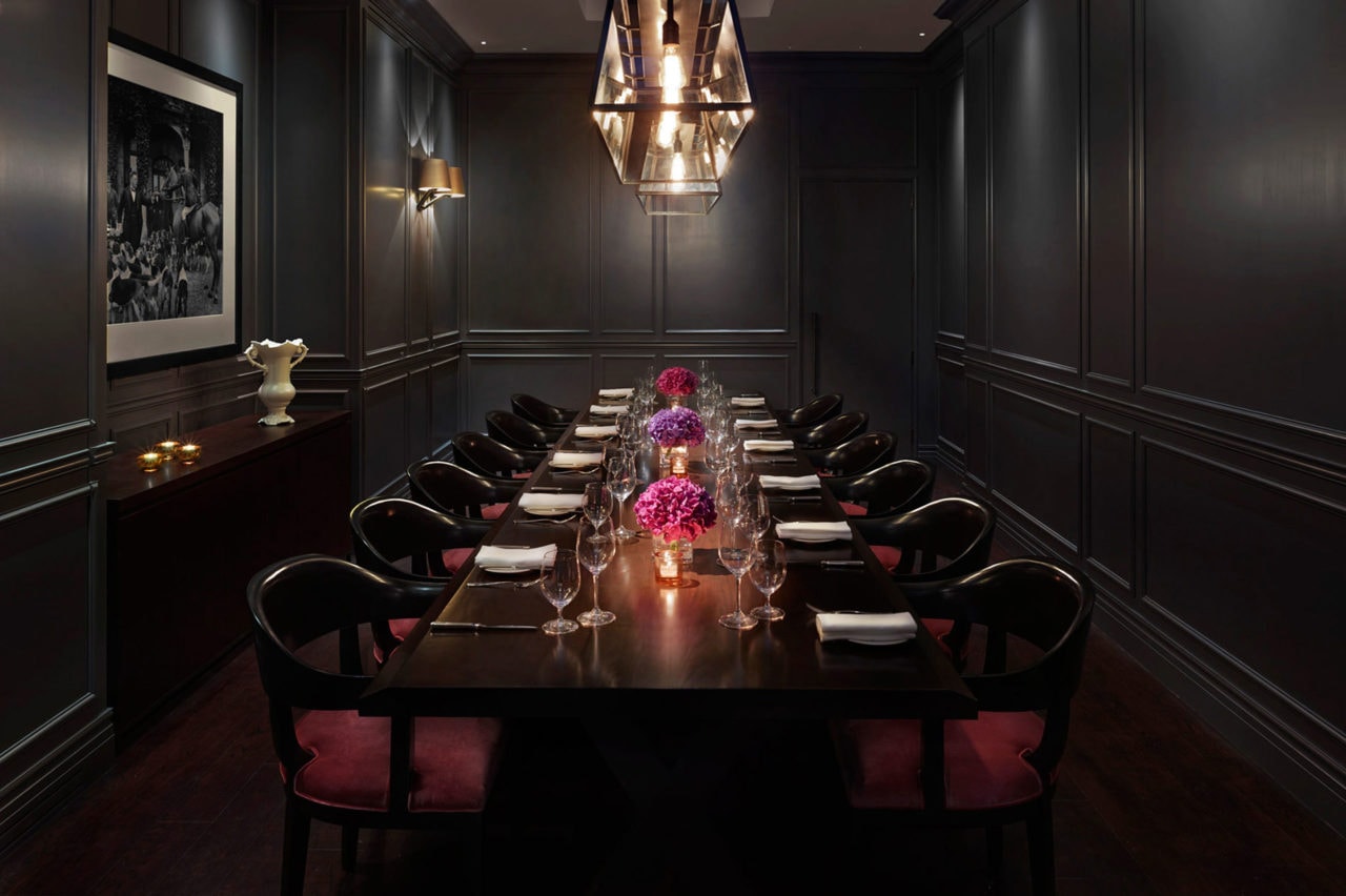 in a London edition hotel restaurant a SENTIENT contemporary design custom live edge table with luxury upholstered chairs