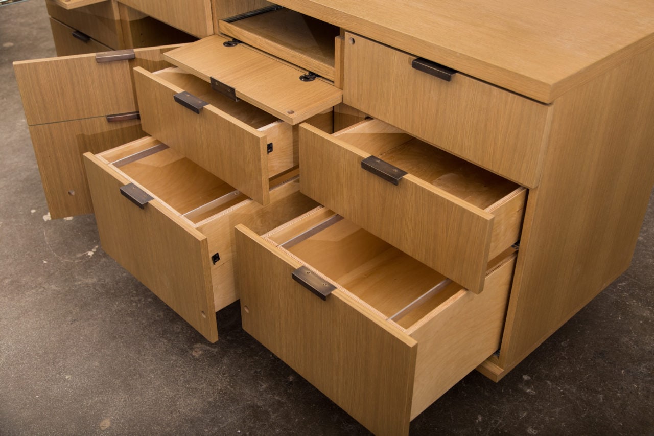 a custom SENTIENT contemporary made wood dresser at an angle with drawers and doors open