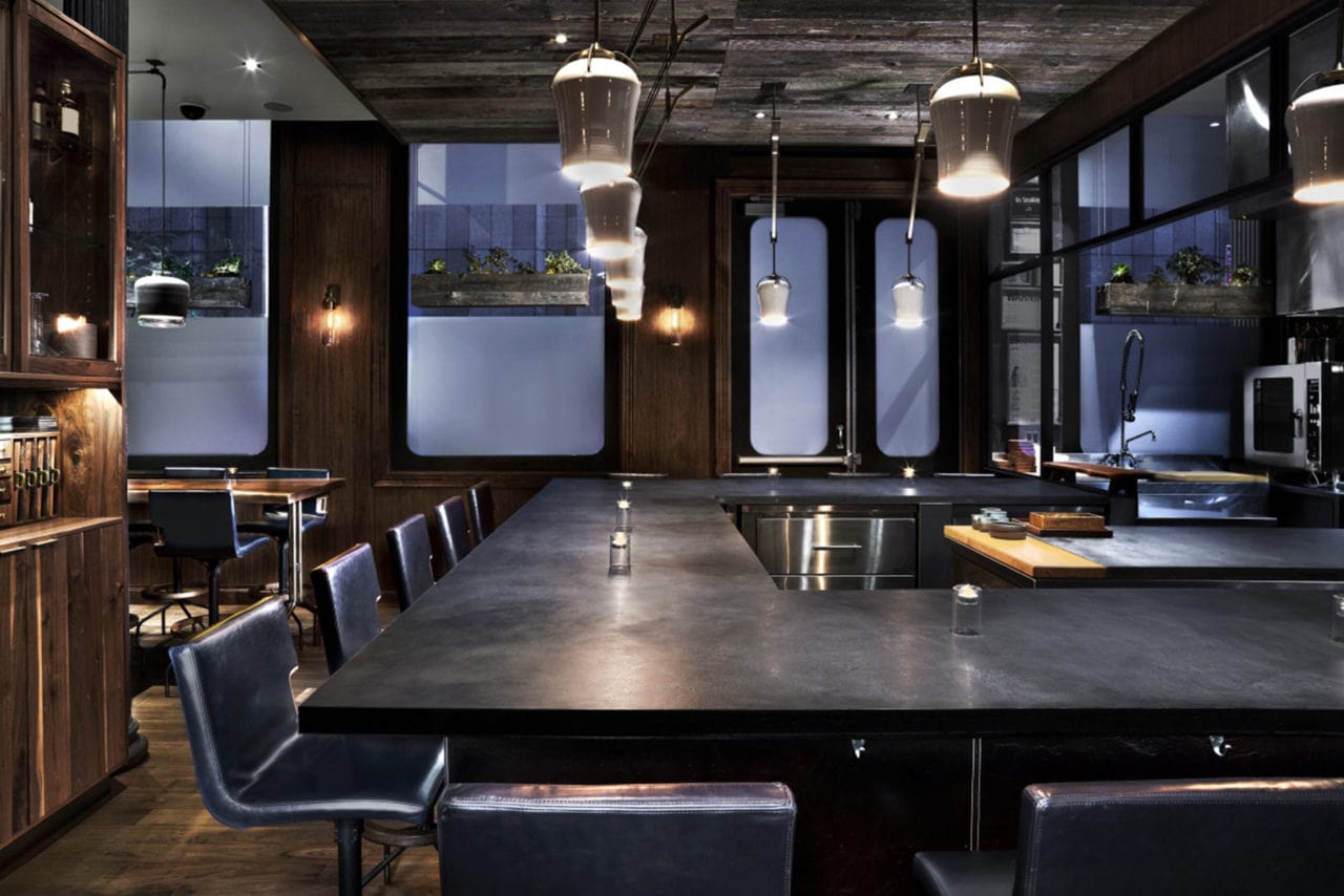 custom SENTIENT contemporary designed live edge table and furniture in atera restaurant with dark stone bar top