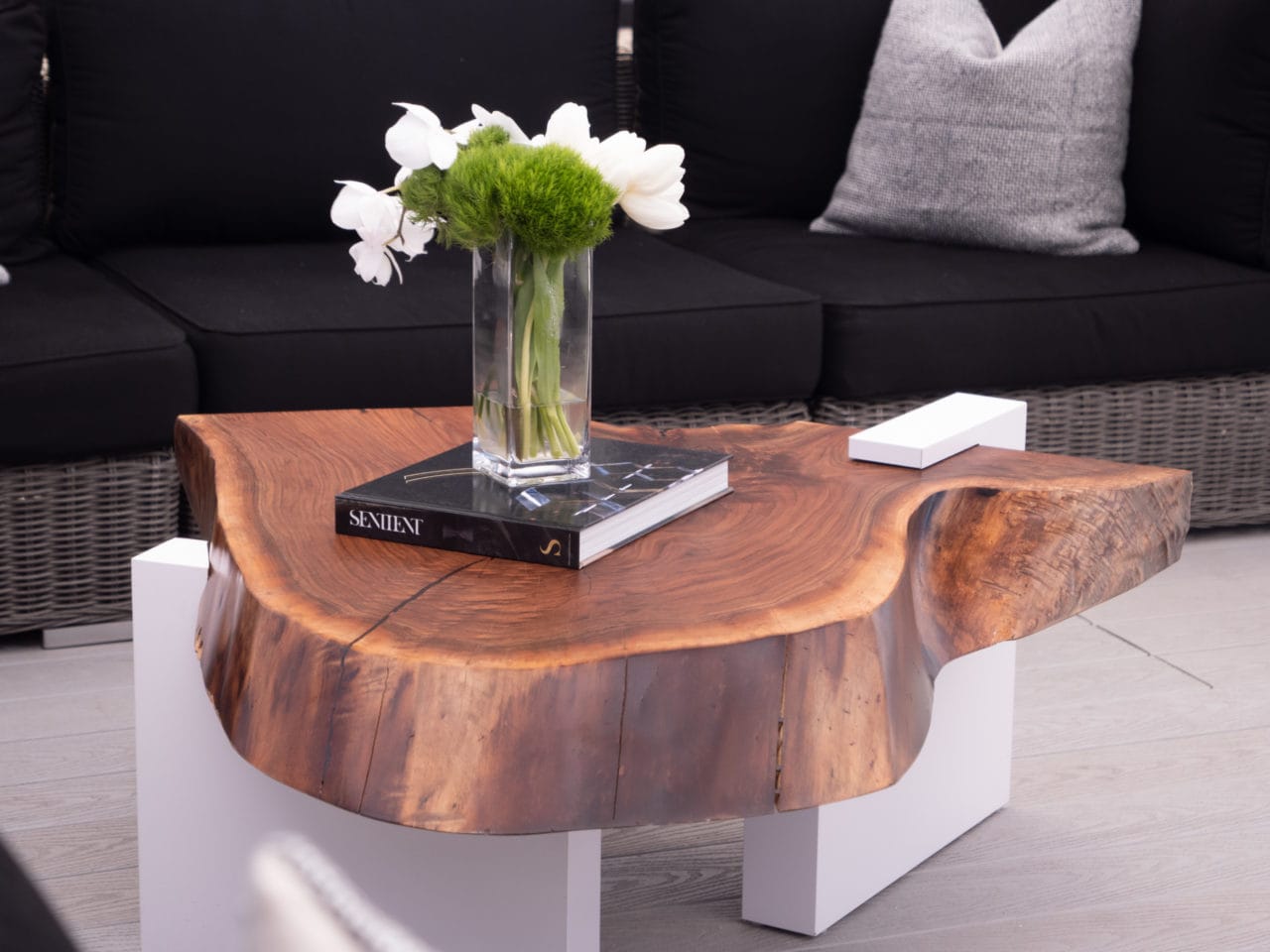 a custom SENTIENT contemporary designed live edge wood coffee table in front of a sofa