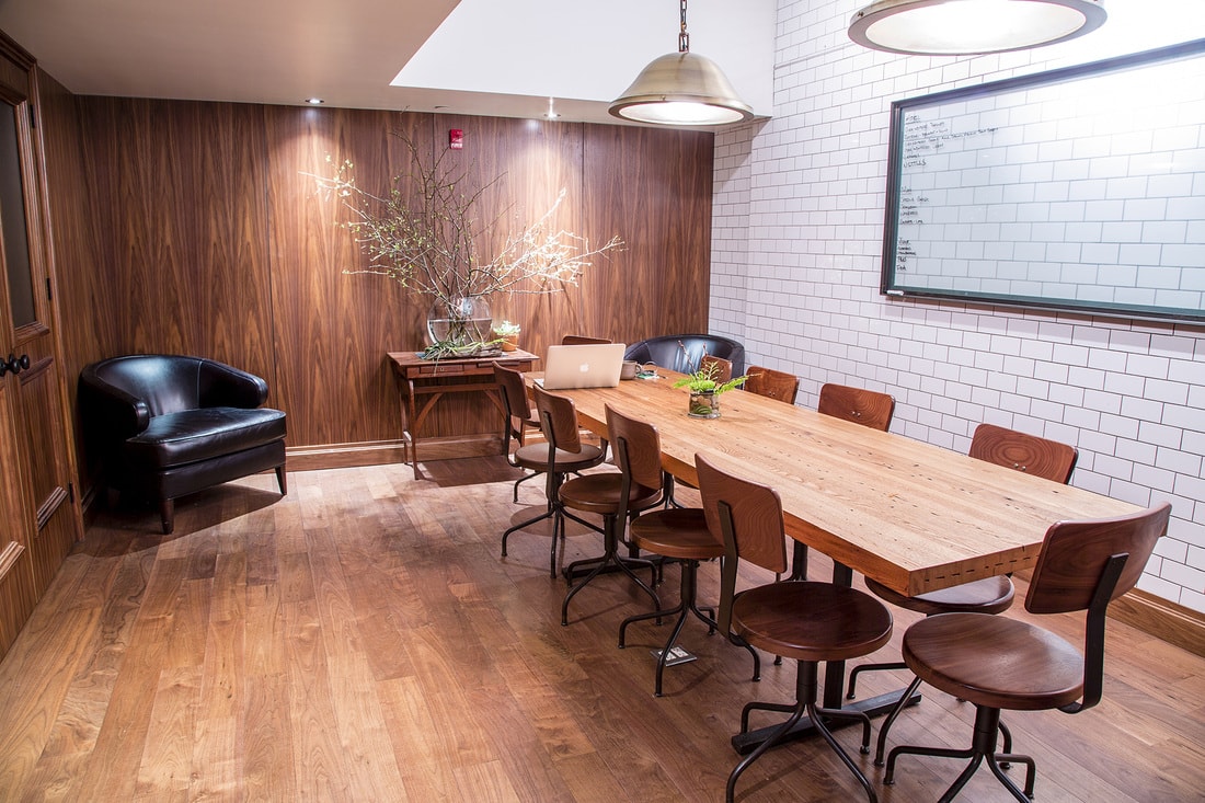 a custom SENTIENT contemporary designed maple wood dinning table in luxury atera restaurant with wood and white brick walls