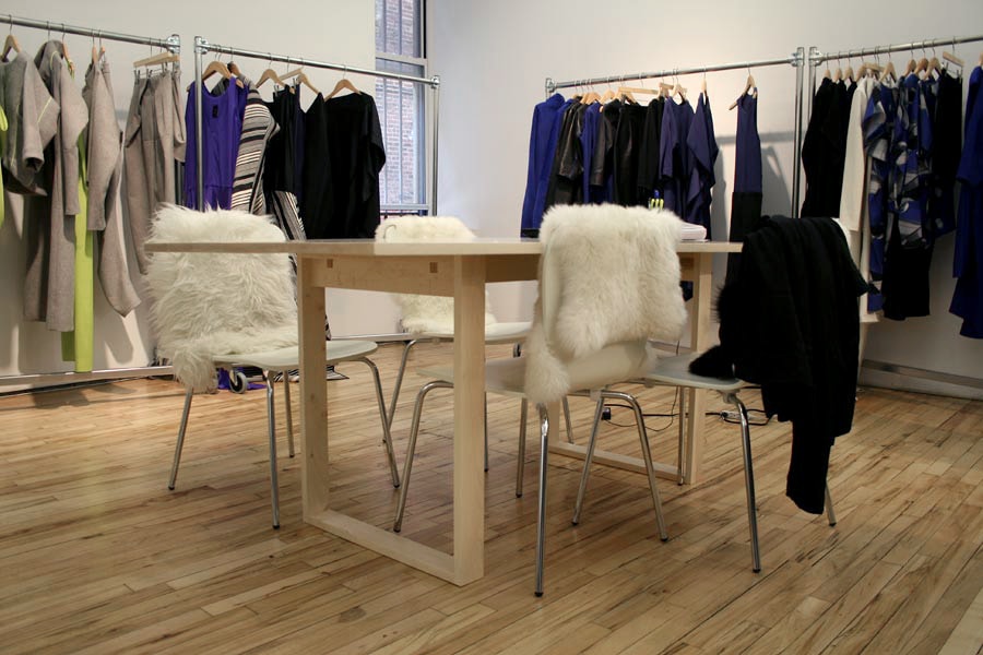 in the retail space zero by Maria a SENTIENT custom contemporary designed maple wood table with luxury sheep skins on chairs
