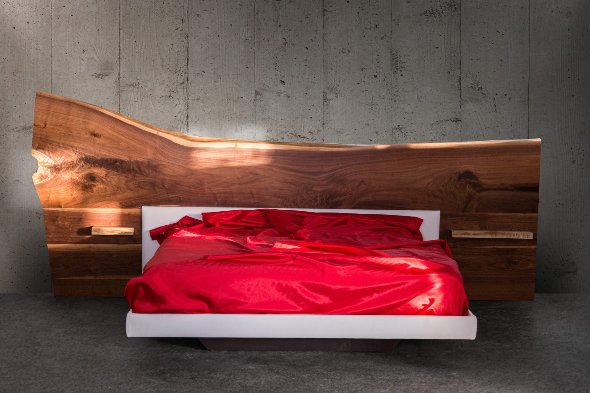 a SENTIENT contemporary live edge headboard platform bed with luxury upholstered railings and red silk sheets 
