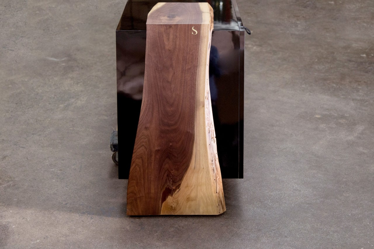 a custom SENTIENT contemporary luxor console table with walnut live edge wood ends and matte black outer shell end view