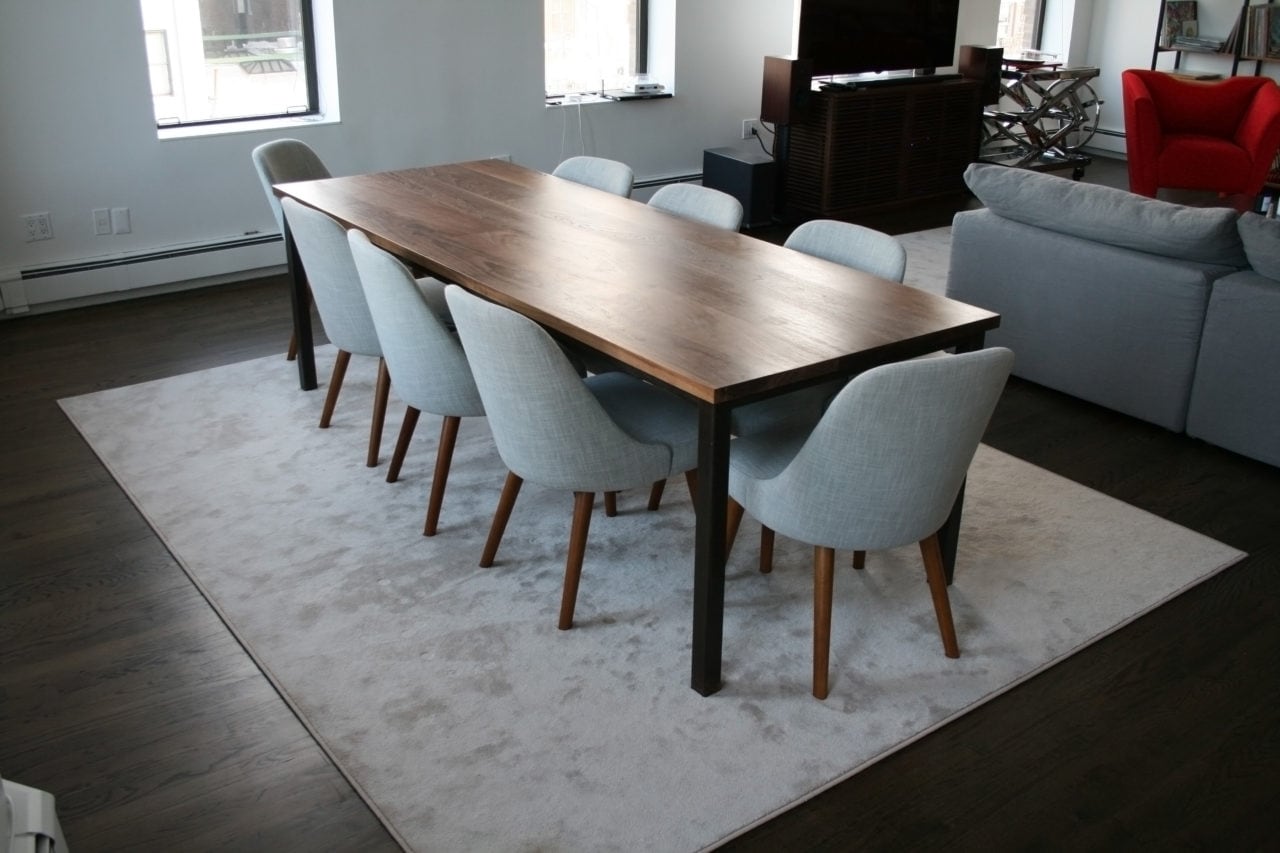 a SENTIENT contemporary designed walnut wood custom dinning table with blue luxury chairs in a living room