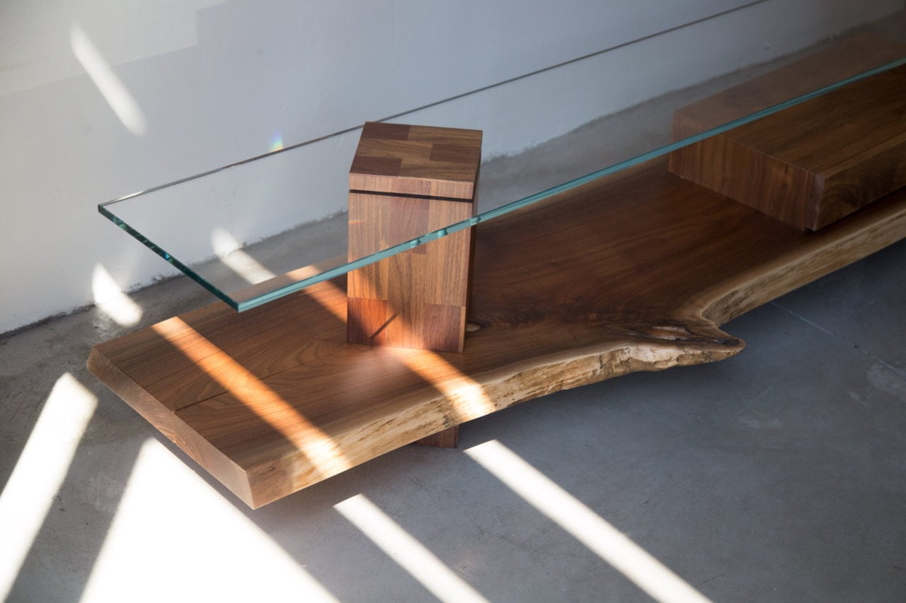 a SENTIENT contemporary designed foothills console in custom walnut and glass top with storage box angled detail view