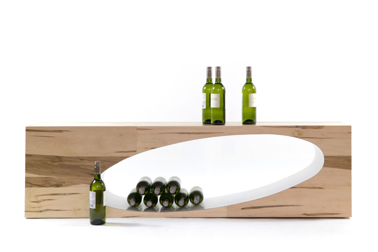 a custom maple SENTIENT contemporary designed Orbit coffee table with oval cutout with wine bottles within