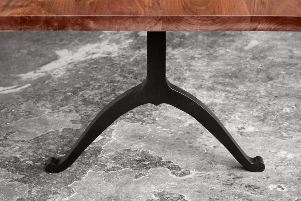 an American black walnut live edge SENTIENT contemporary solid wood luxury table detail with blackened steel wishbone leg