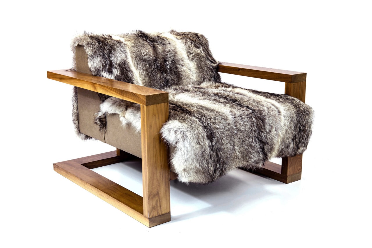 a SENTIENT contemporary designed caribou custom chair in walnut and luxury fur sitting facing side ways