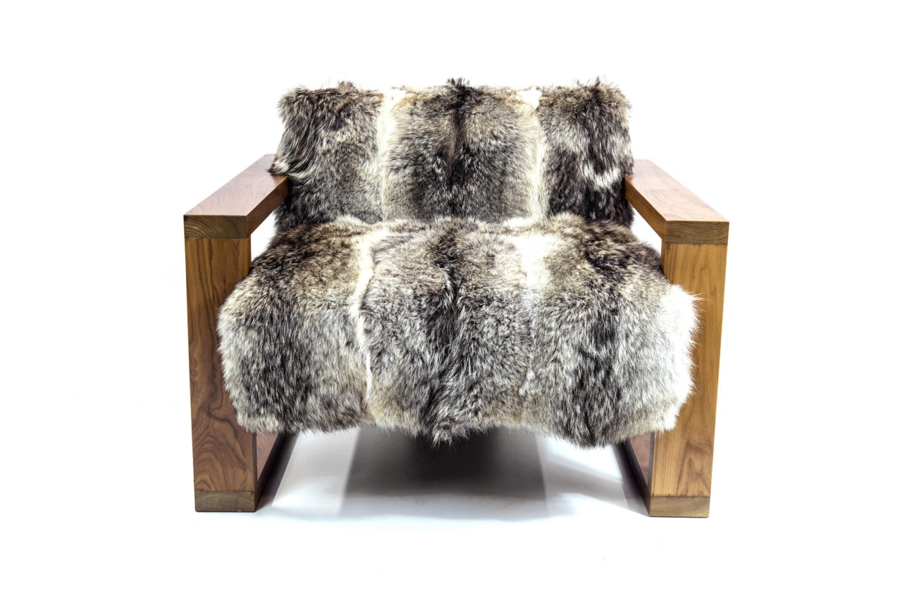 a SENTIENT contemporary designed caribou custom chair in walnut and luxury fur sitting at an angled right