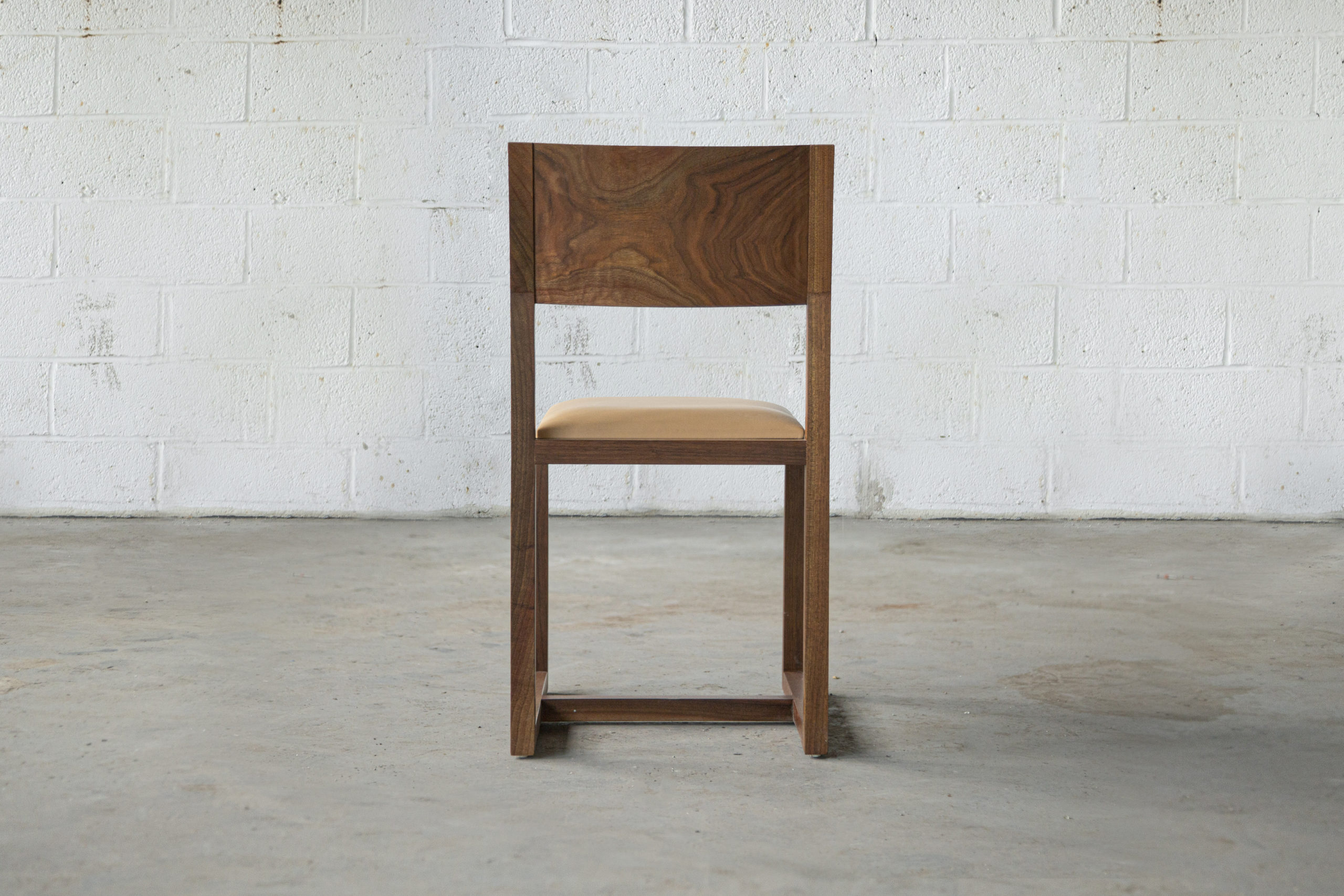 a contemporary designed SENTIENT Saint Lawrence custom dining chair of walnut and luxury leather seat arial back view