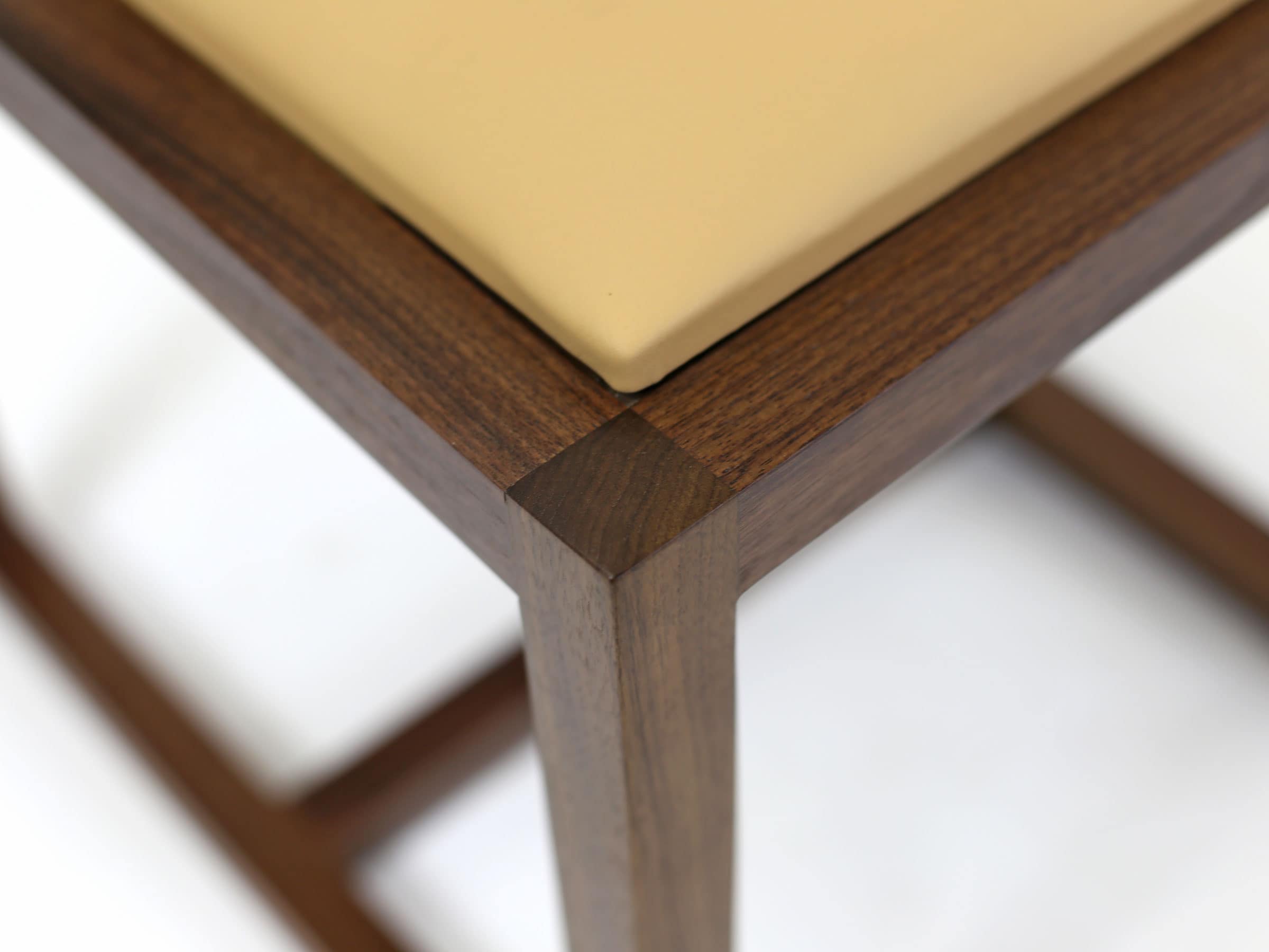 a contemporary designed SENTIENT Saint Lawrence custom dining chair of walnut and luxury leather seat corner detail view