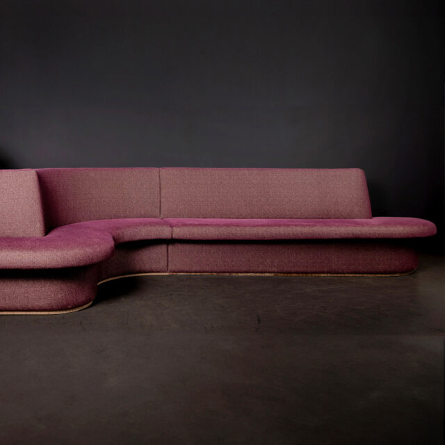 A long custom made banquette with curved angles in purple color