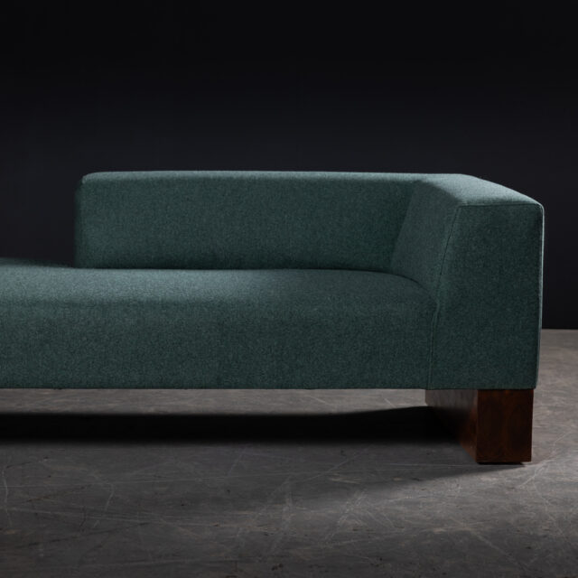 A minimalist green Beem sofa featuring a single-arm design and a contemporary, block-style structure