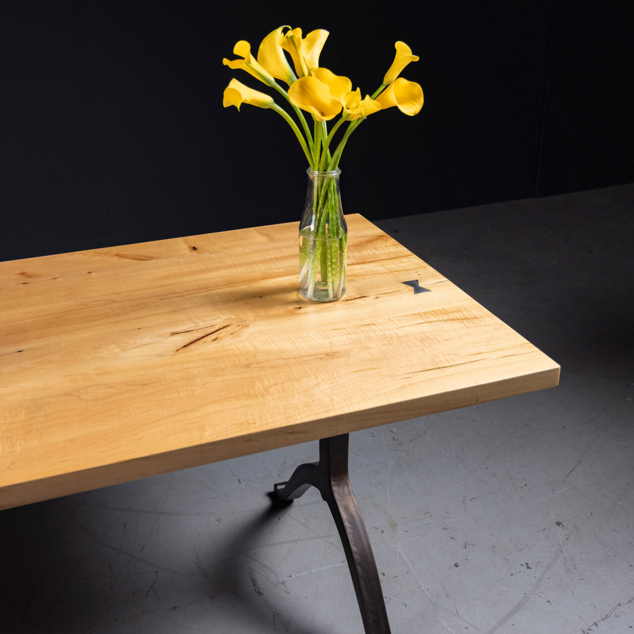 Dining table with a splatted maple top, featuring a modern design with butterfly inlays.