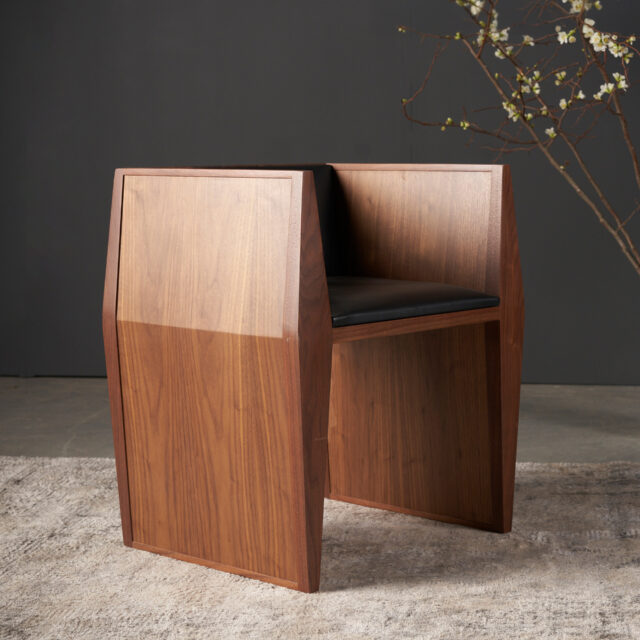 The SENTIENT Sapience chair with a geometric design and intricate artistic details on the wood.