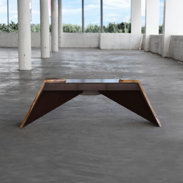 Time When console table with angled walnut wood supports and a sleek modern tabletop, set in an industrial interior.