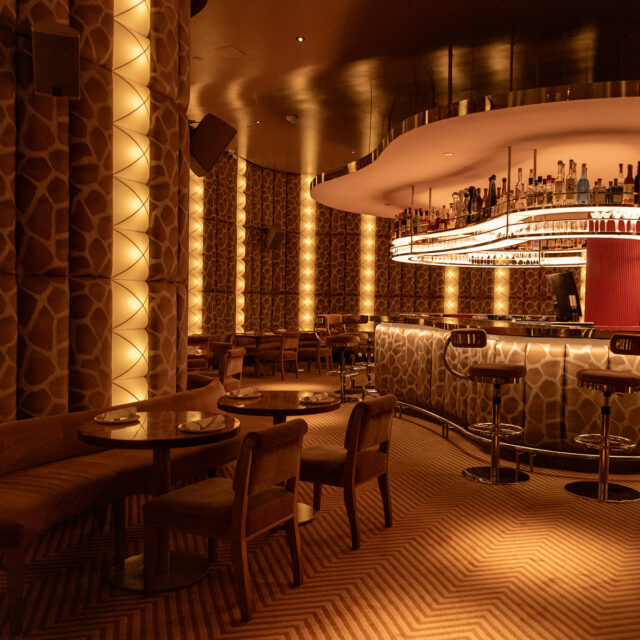 Obvio Cocktail bar interior with upholstered panels covering the walls and custom tables made by SENTIENT